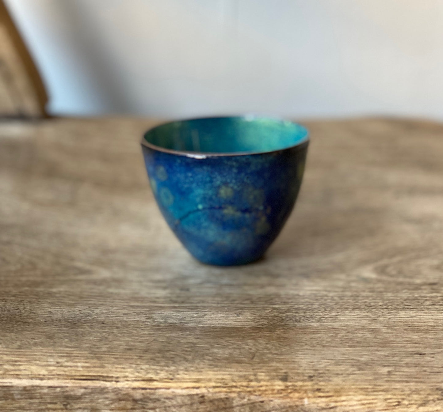 Small decorative blue vessel with green details, enamel on copper